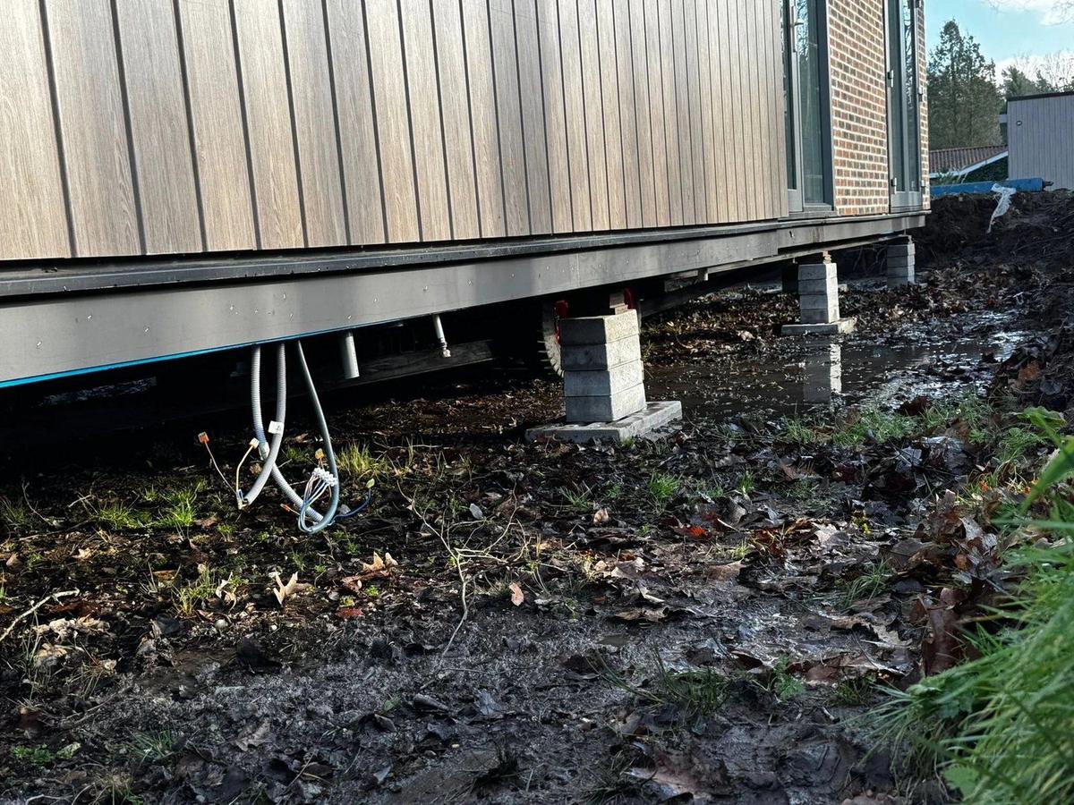 Stapels bielzen onder de lange zijde van een woning