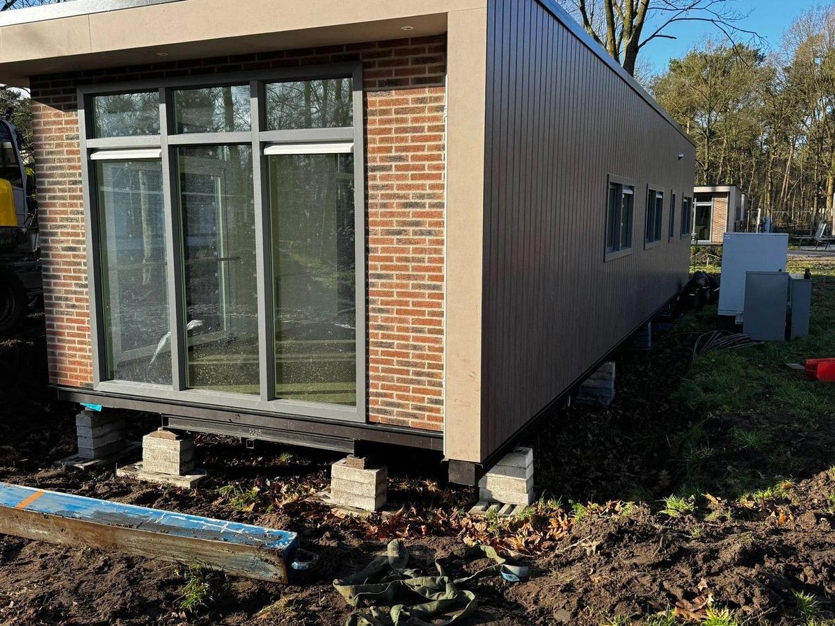 Een vakantiewoning met houten gevel staat op bielzen